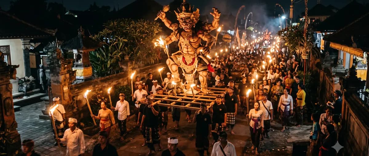 Arak-arakan budaya tradisional Indonesia dengan obor dan patung ogoh-ogoh pada malam hari