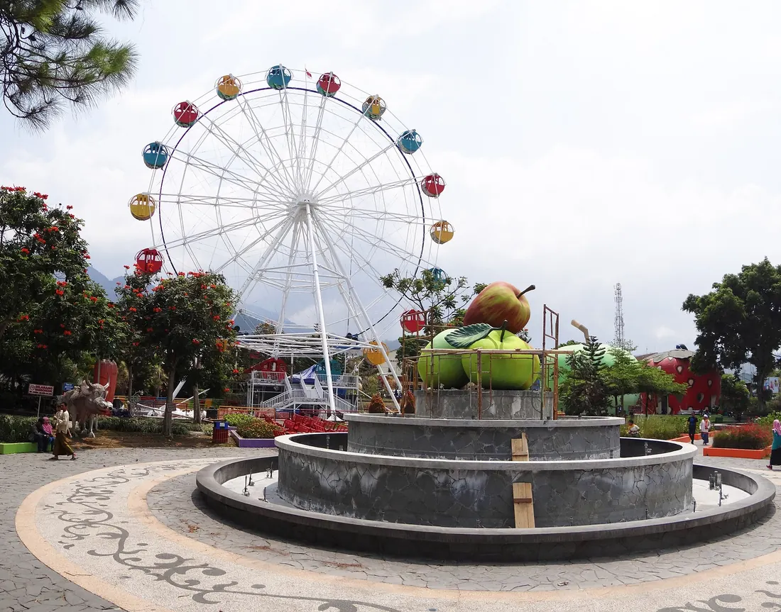 Alun-Alun Kota Batu dengan bianglala kecil dan air mancur berhias patung apel raksasa