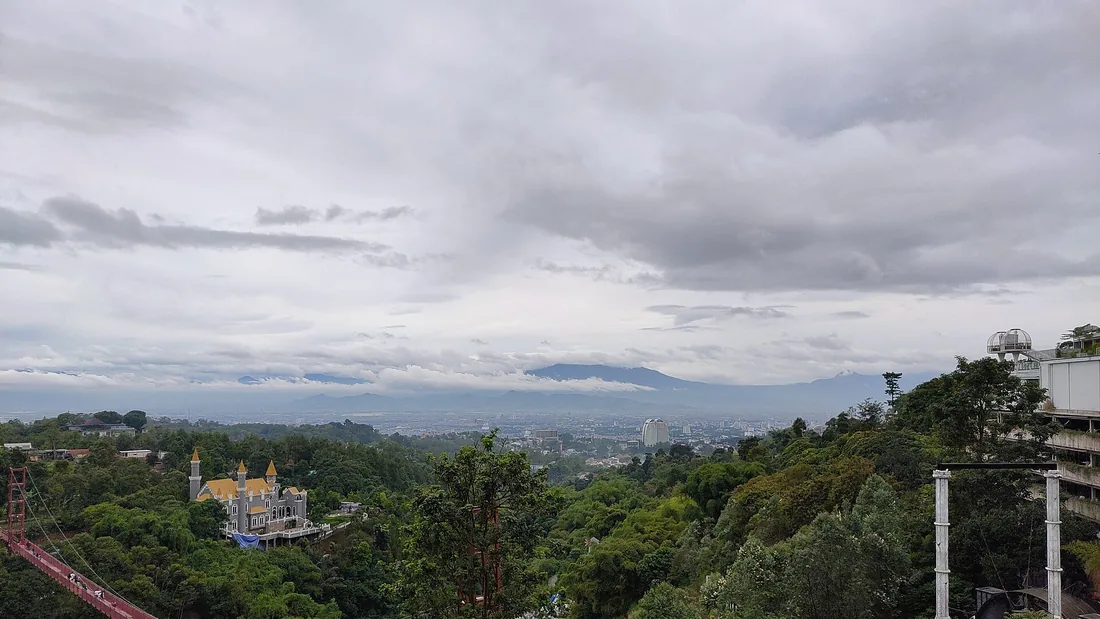 Lembah Bandung dilihat dari Pagerwangi, Lembang, pada hari berawan dengan punggungan Gunung Malabar di kejauhan