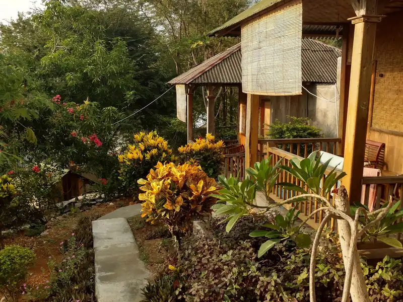 Deretan bungalow kayu beratap seng dengan beranda dan taman di Labuan Bajo