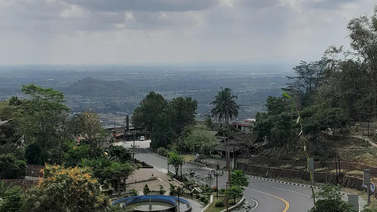 Tikungan Jalan Raya Jogja-Wonosari di tanjakan Pathuk dengan dataran Yogyakarta terlihat di kejauhan pada siang hari