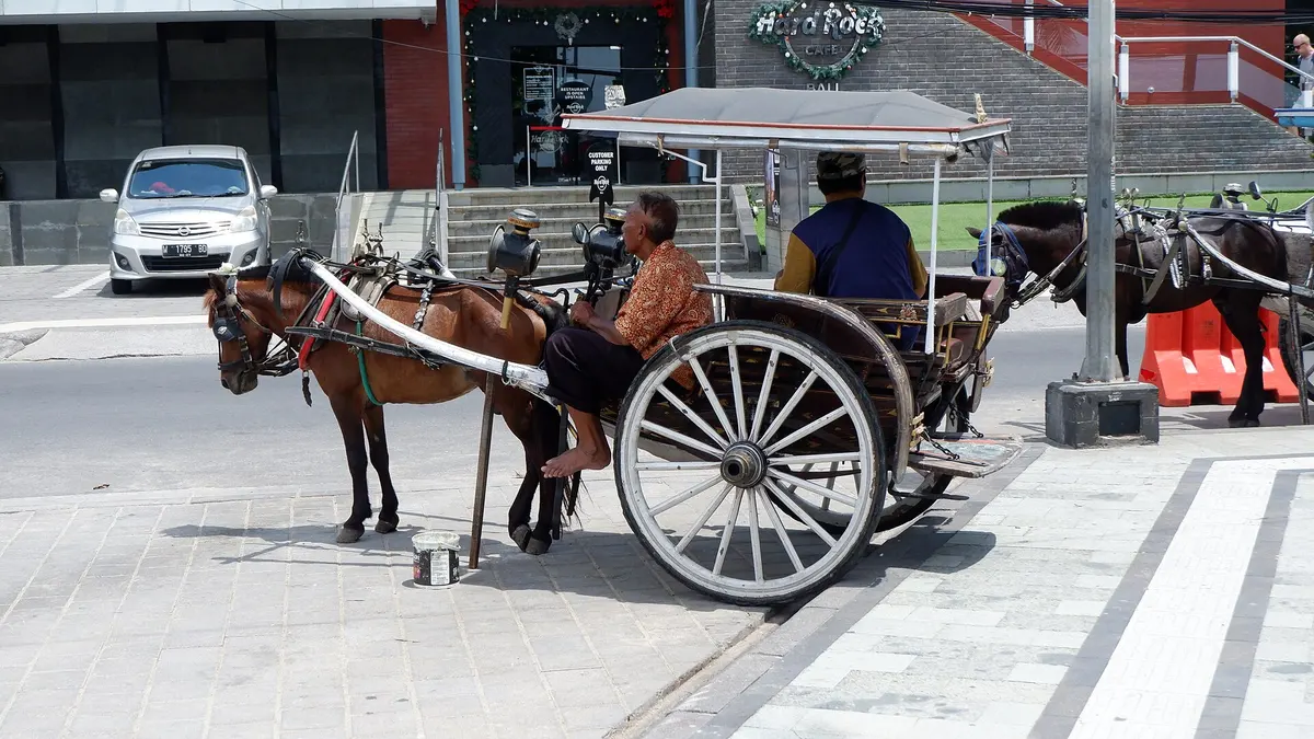 Andong atau kereta kuda menunggu penumpang di jalan sepanjang Pantai Kuta Bali