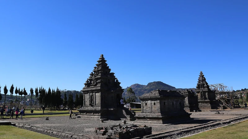 Kompleks Candi Arjuna di Dataran Tinggi Dieng dengan latar perbukitan dan langit cerah