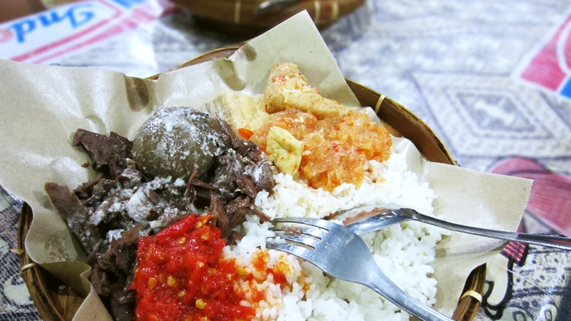 Sepiring gudeg Yogyakarta dengan nasi, telur pindang, sambal krecek, dan tahu bacem di atas pincuk