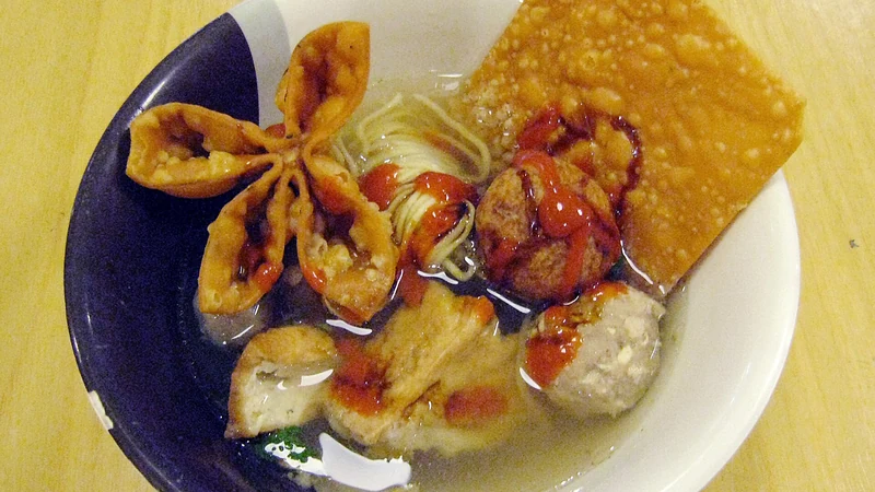 Semangkuk bakso Malang berisi bakso urat, tahu isi, mi, dan pangsit goreng dengan kuah bening